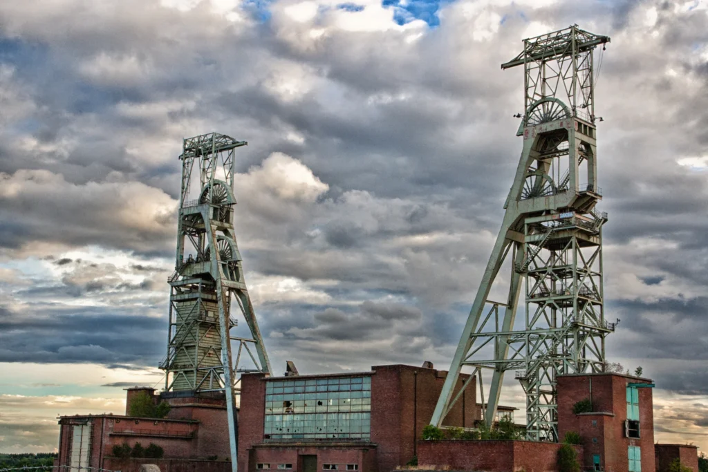 Former coal mine headstocks beneath a dramatic cloudy sky.