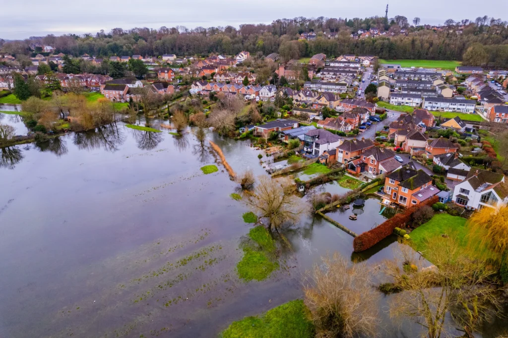 Aerial view of floodwater reaching homes beside a river.