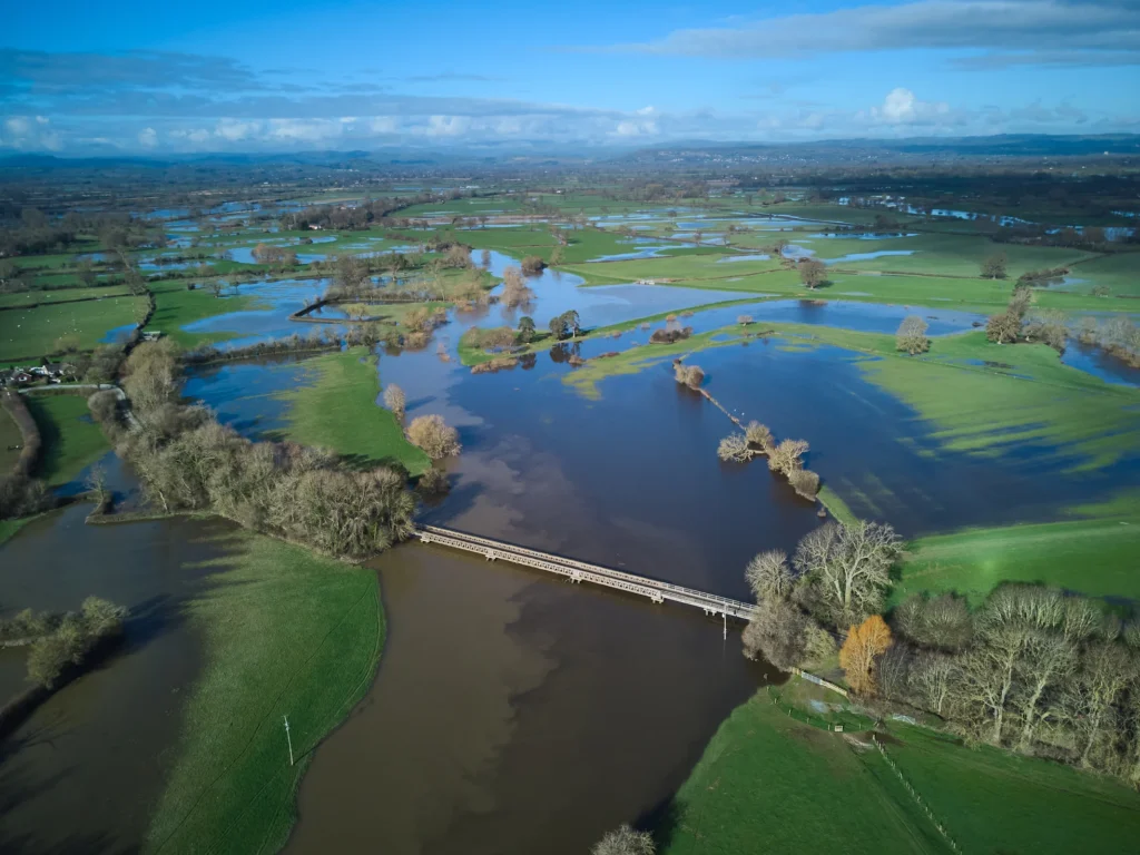 Aerial view of a flooded river and surrounding agricultural fields.